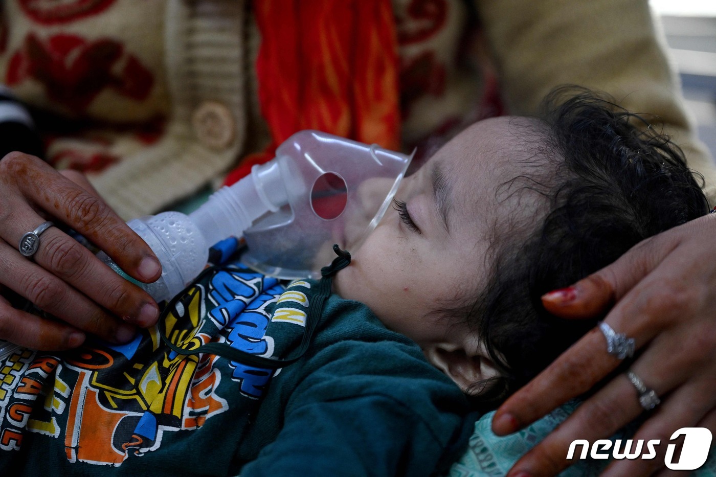 (뉴델리 AFP=뉴스1) 정지윤 기자 = 7일(현지시간) 인도 뉴델리의 한 어머니가 어린이 병원의 응급 병동에서 네뷸라이저를 이용해 아이의 호흡을 돕고 있다. 뉴델리는 매년 겨울 …