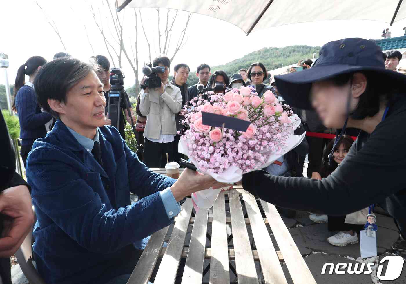 조국 전 법무부 장관이 9일 오후 경남 양산시 하북면 평산책방에서 열린 '디케의 눈물' 작가 사인회에서 한 시민에게 꽃다발을 받고 있다. 2023.11.9/뉴스1 © News1 윤일지 기자