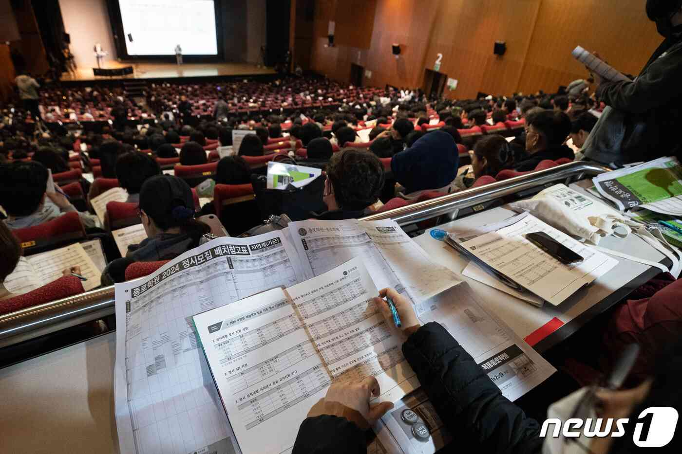 수험생 및 학부모들이 10일 서울 종로구 성균관대 600주년 기념관에서 열린 종로학원 '2024 정시지원 변화 및 합격선 예측, 합격전략' 설명회에서 정시배치참고표 및 자료집을 살펴보고 있다. 2023.12.10/뉴스1 © News1 유승관 기자