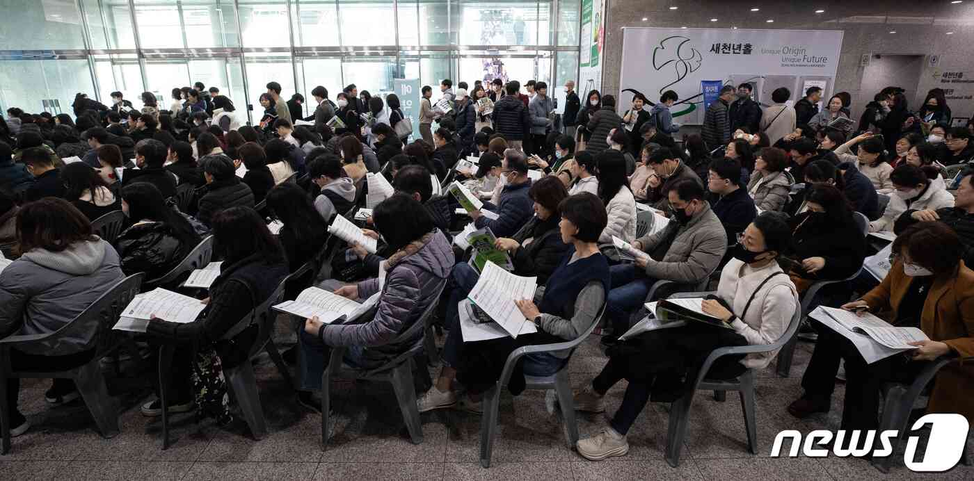 수험생 및 학부모들이 10일 서울 종로구 성균관대 600주년 기념관에서 열린 종로학원 '2024 정시지원 변화 및 합격선 예측, 합격전략' 설명회에서 설명회장 밖에 마련된 좌석에 앉아 정시배치참고표 및 자료집을 살펴보고 있다. 2023.12.10/뉴스1 © News1 유승관 기자