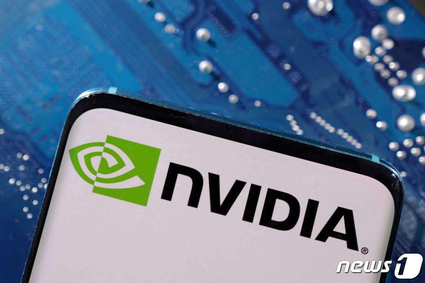 본문 이미지 - 컴퓨터 머더보드를 배경으로 한 스마트폰에 엔비디아 로고가 떠 있다. 2023.3.6 ⓒ 로이터=뉴스1 ⓒ News1 강민경 기자