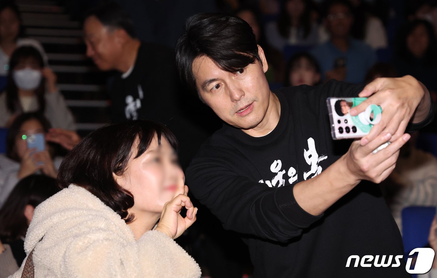 본문 이미지 - 배우 정우성이 12·12 군사 쿠데타 44주년을 하루 앞둔 11일 오후 서울 송파구 롯데시네마 월드타워점에서 열린 영화 ‘서울의 봄’ 무대인사에 참석해 한 여성팬과 셀카를 찍고 있다. 2023.12.11/뉴스1 ⓒ News1 김진환 기자