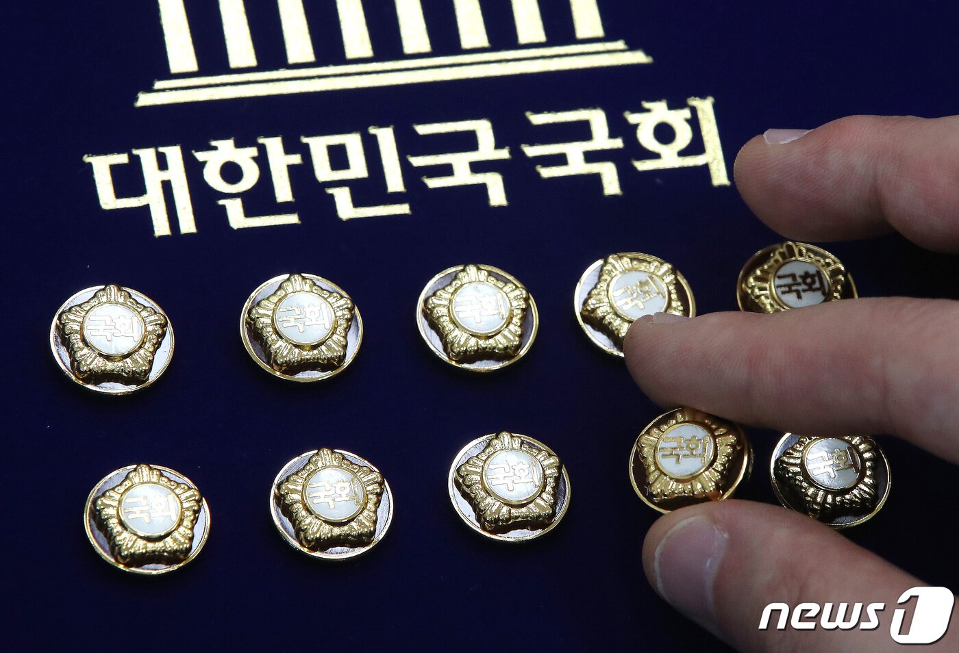 본문 이미지 - 제22대 국회의원 선거(총선) 예비후보자 등록 시작일인 지난 12일 서울 여의도 국회 사무처에서 한 직원이 국회의원 배지를 정리하고 있다. 총선 후보자 등록은 내년 3월 21일부터 22일까지 진행된다. 이어 3월27일부터 4월1일까지 재외투표가 실시, 4월5일부터 6일까지 이틀간 사전투표가 실시되며 선거 당일인 10일은 오전 6시부터 오후 6시까지 투표가 진행된다. 2023.12.12/뉴스1 ⓒ News1 임세영 기자