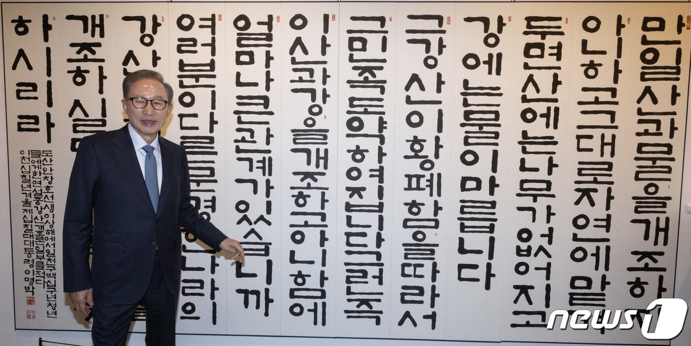본문 이미지 - 이명박 전 대통령이 13일 오후 서울 서초구 한전아트센터에서 열린 첫 서예전 '스며들다' 개막식에서 자신에 작품을 배경으로 포즈를 취하고 있다. 2023.12.13/뉴스1 ⓒ News1 이재명 기자