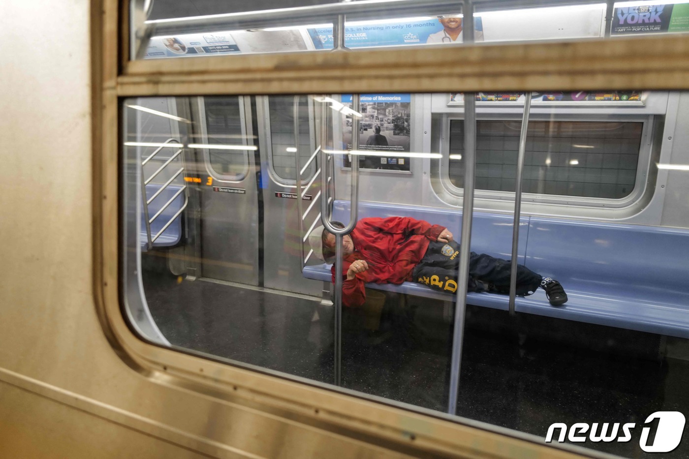 (뉴욕 AFP=뉴스1) 정지윤 기자 = 13일(현지시간) 미국 뉴욕의 맨해튼의 지하철에서 한 노숙자가 좌석에 누워 잠을 청하고 있다. 2023.12.13ⓒ AFP=뉴스1