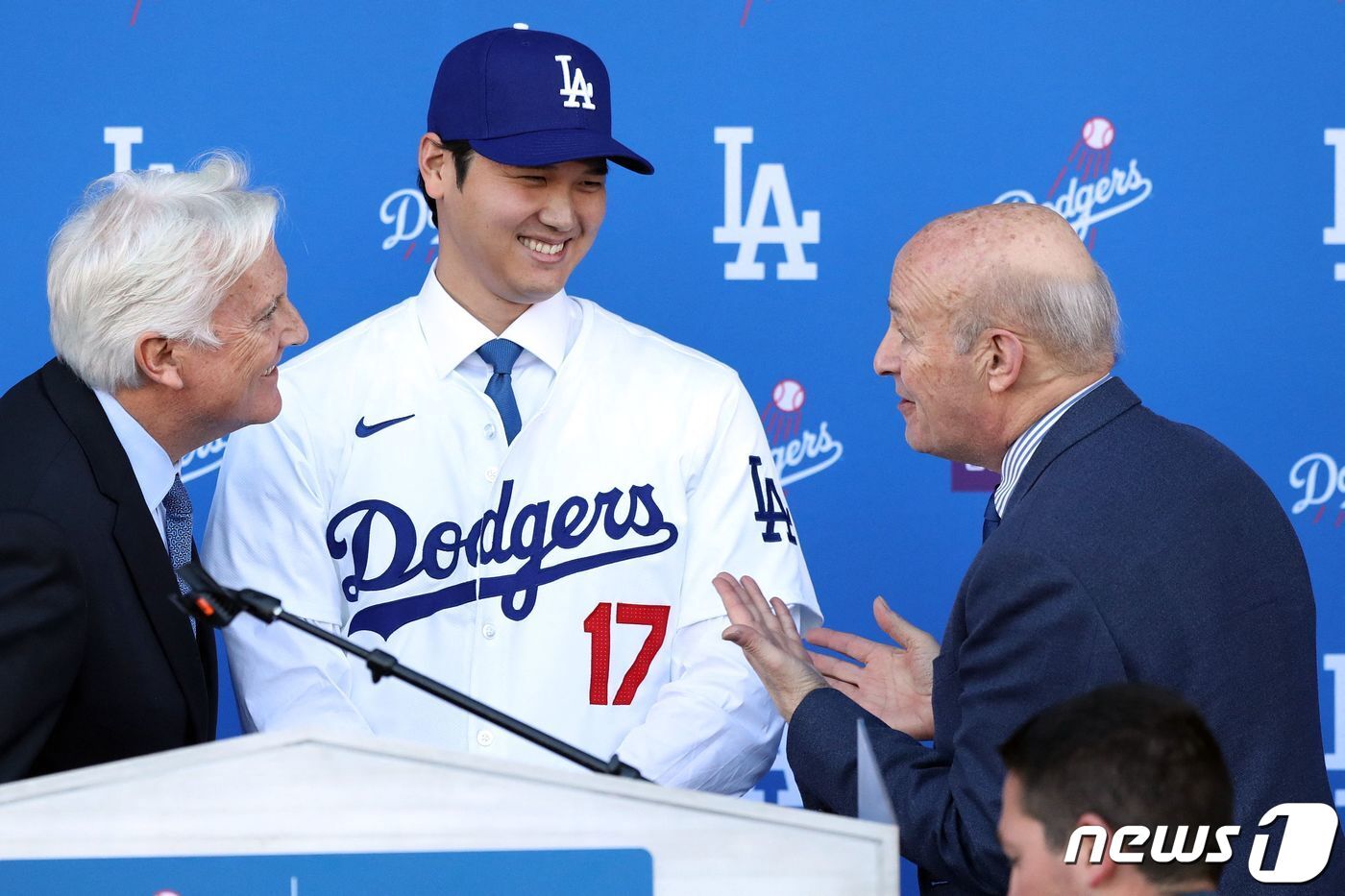 본문 이미지 - 오타니 쇼헤이가 14일 (현지시간) 캘리포니아주 로스앤젤레스 다저 스타디움에서 세계 프로 스포츠 사상 역대 최고액인 10년 9000억 원에 계약한 LA 다저스 입단식서 마크 월터 구단주, 스탠 카스텐 CEO와 얘기를 하고 있다. 2023.12.15 ⓒ AFP=뉴스1 ⓒ News1 우동명 기자