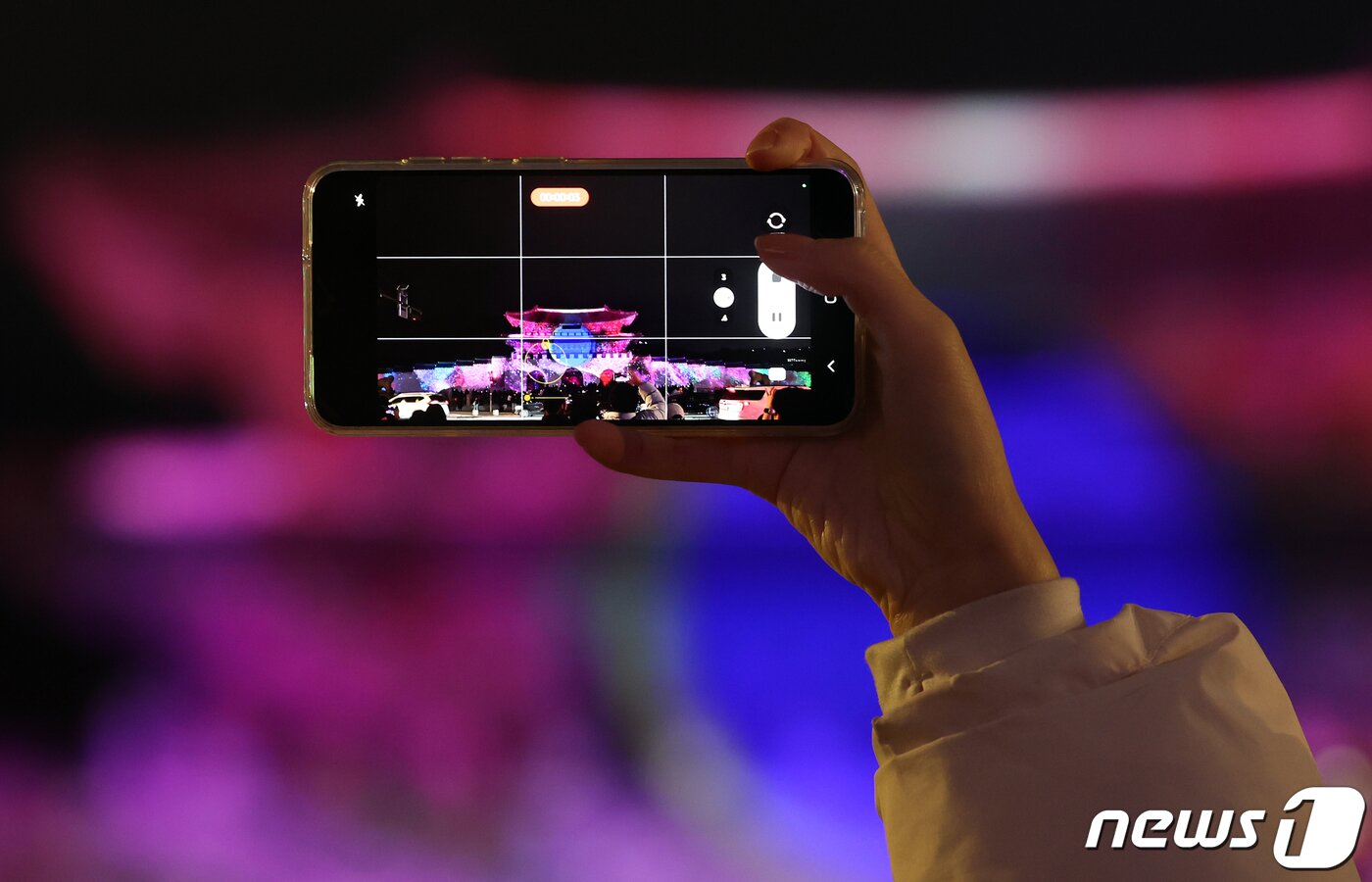 본문 이미지 - 15일 오후 서울 세종대로 광화문광장에서 열린 ‘2023 서울빛초롱축제’에서 한 시민이 광화문 외벽에 투영되는 미디어파사드를 스마트폰으로 촬영하고 있다. 이번 행사는 이날 개막해 내년 1월 21일까지 38일간 진행된다. 2023.12.15/뉴스1 ⓒ News1 김진환 기자