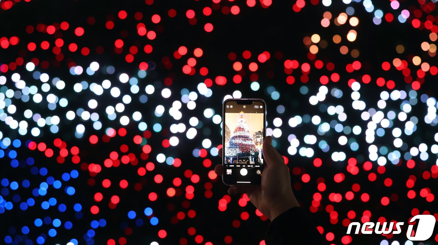 본문 이미지 - 15일 오후 서울 세종대로 광화문광장에서 열린 ‘2023 서울빛초롱축제’에서 한 시민이 미디어트리를 스마트폰으로 촬영하고 있다. 이번 행사는 이날 개막해 내년 1월 21일까지 38일간 진행된다. 2023.12.15/뉴스1 ⓒ News1 김진환 기자