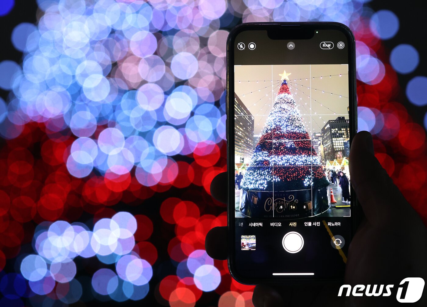 본문 이미지 - 15일 오후 서울 세종대로 광화문광장에서 열린 ‘2023 서울빛초롱축제’에서 한 시민이 미디어트리를 스마트폰으로 촬영하고 있다. 이번 행사는 이날 개막해 내년 1월 21일까지 38일간 진행된다. 2023.12.15/뉴스1 ⓒ News1 김진환 기자