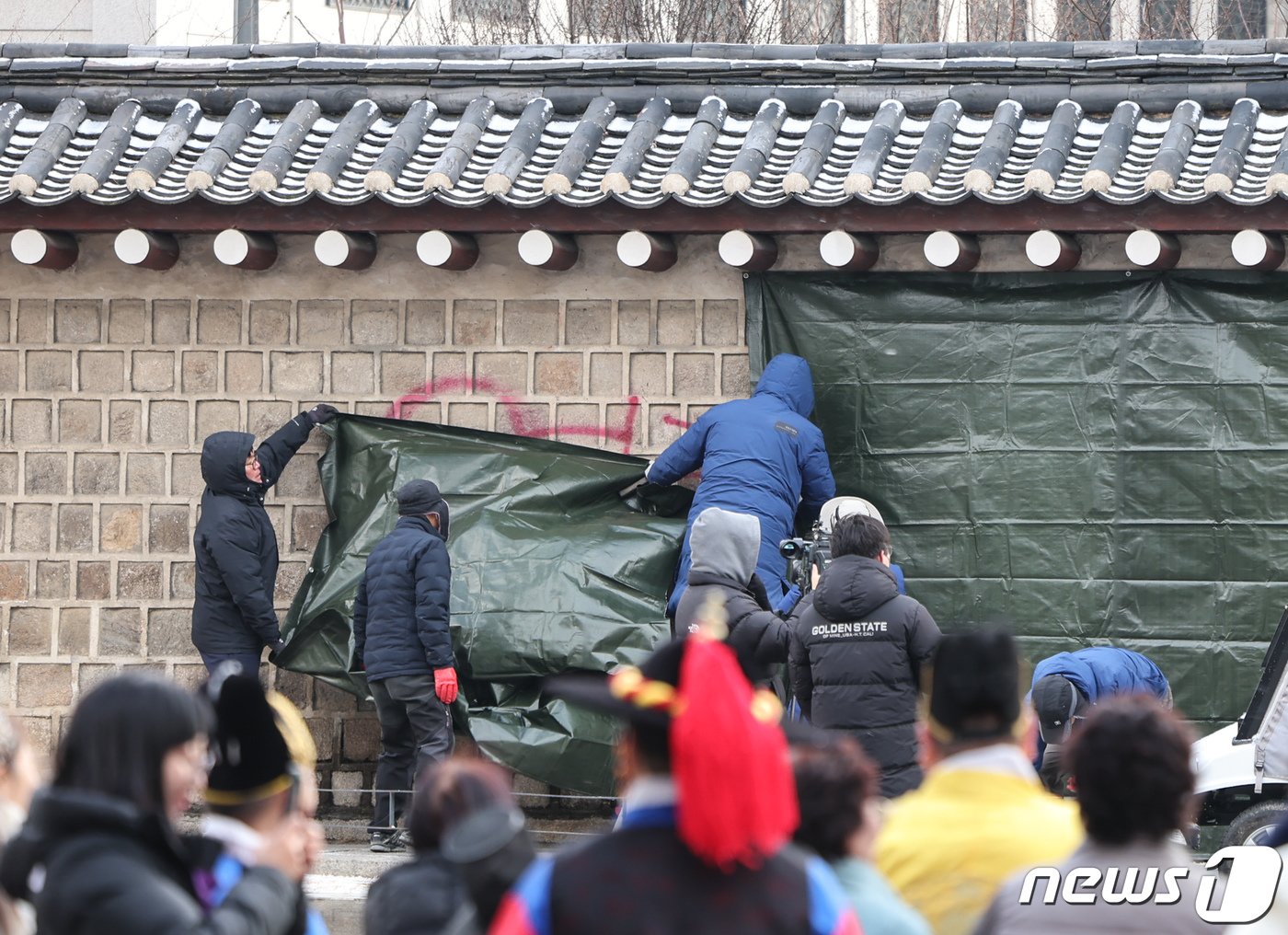 본문 이미지 - 경복궁 관리소 직원들이 16일 오전 서울 종로구 경복궁 서쪽 담벼락에 낙서로 훼손된 부분을 천막으로 가리고 있다. 16일 종로경찰서에 따르면 이날 오전 2시 20분께 국립고궁박물관 방향 경복궁 서쪽 담벼락에 스프레이로 낙서가 돼 있다는 신고가 들어와 용의자를 추적 중이다. 2023.12.16/뉴스1 ⓒ News1 김도우 기자