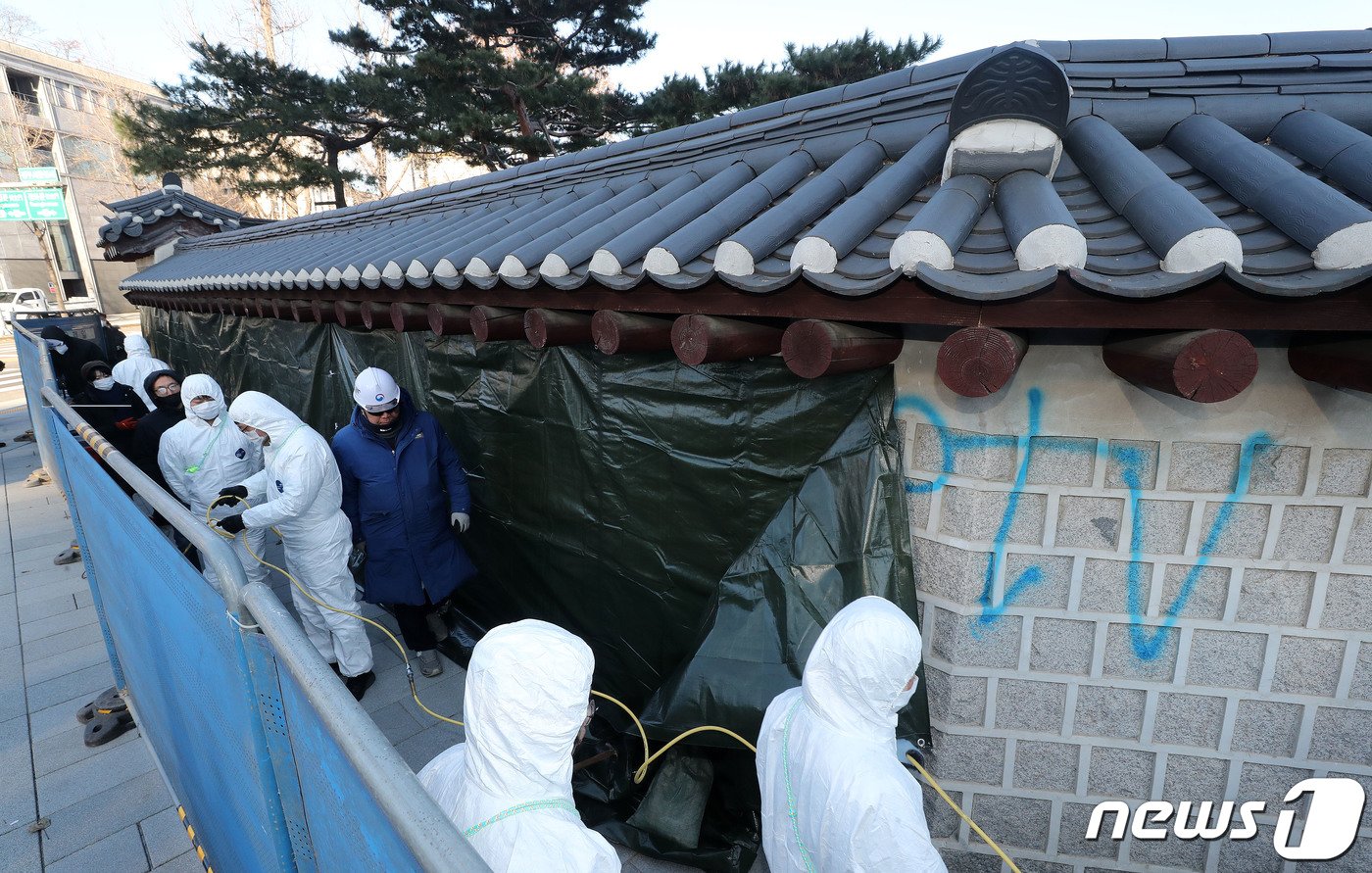 문화재청 관계자들이 17일 오전 서울 종로구 경복궁 서쪽 담장에 새겨진 낙서 제거작업을 하고 있다. 2023.12.17./뉴스1 ⓒ News1 박세연 기자