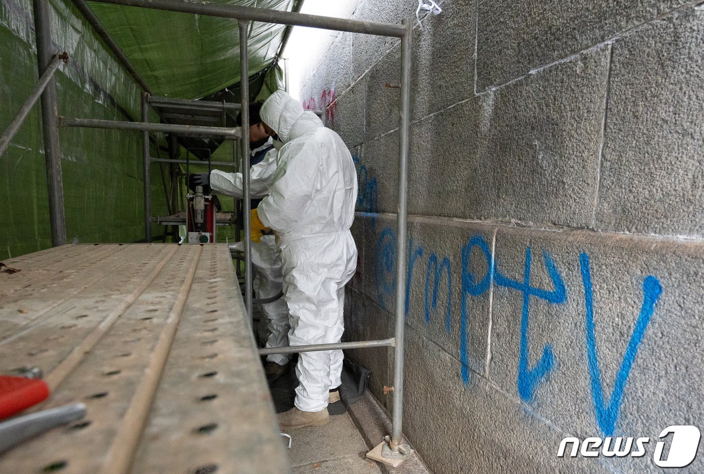 본문 이미지 - 문화재청 관계자들이 19일 오전 서울 종로구 경복궁 영추문 인근에 새겨진 낙서 제거작업을 하고 있다. 2023.12.19/뉴스1 ⓒ News1 이재명 기자