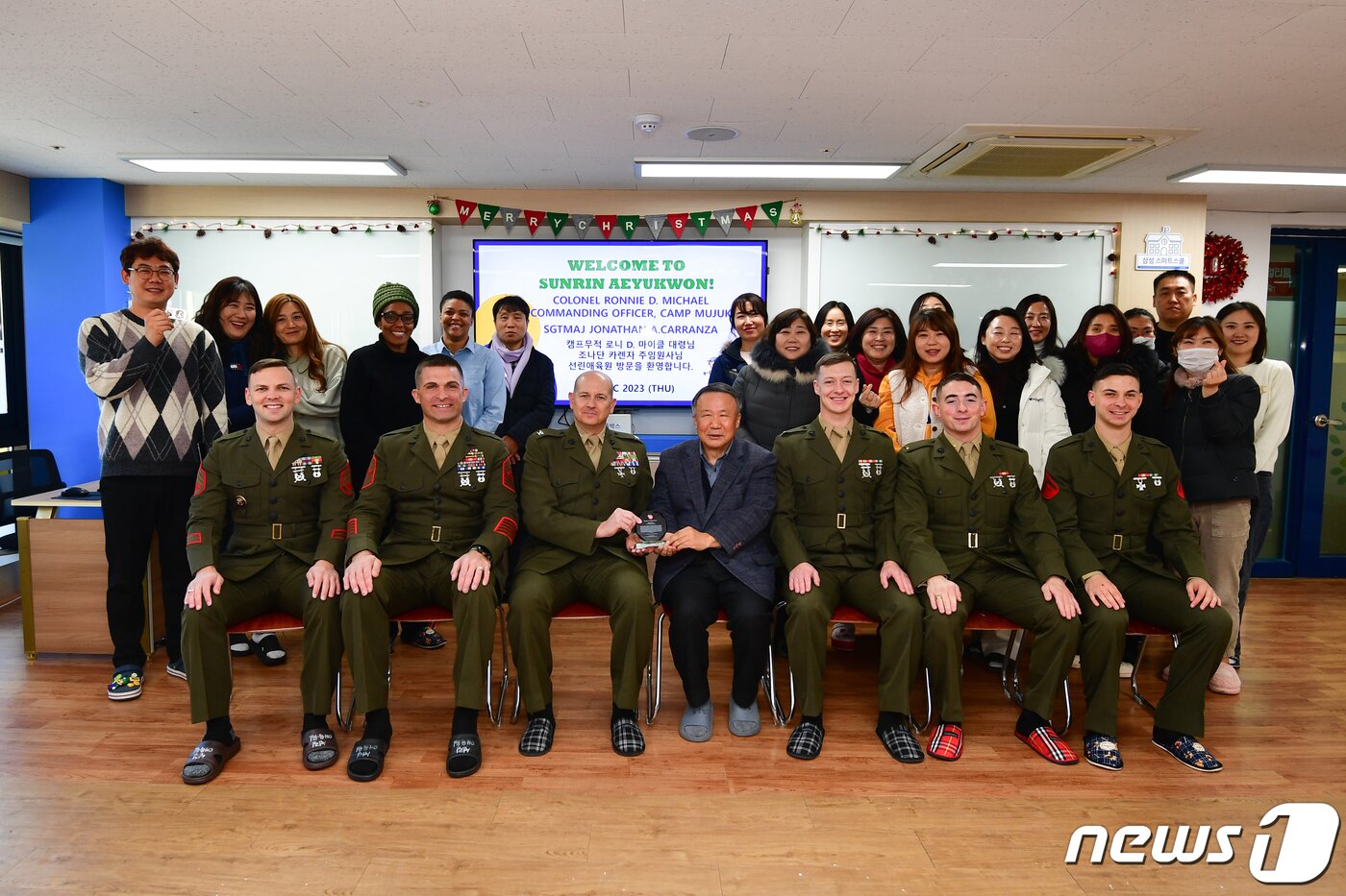 본문 이미지 - 21일 오전 경북 포항시 북구 선린애육원 벽화 제막식에서 로니 D.마이클 캠프무적 부대장(대령)과 박정민 선린애육원장, 무적캠프 장병, 선린애육원 관계자들이 벽화 제막식을 마친 후 기념촬영을 하고 있다. .2023.12.21/뉴스1 ⓒ News1 최창호 기자