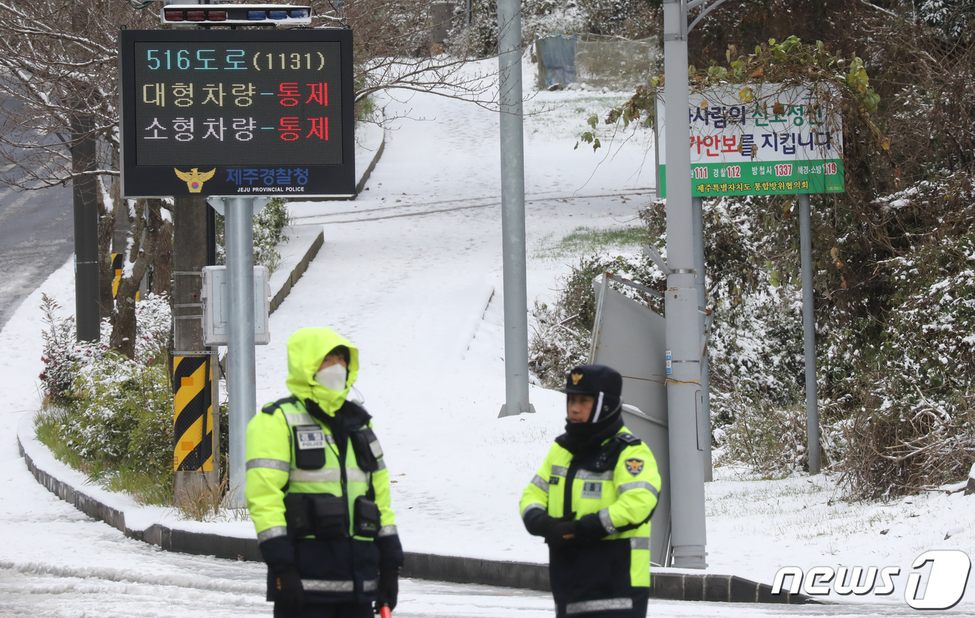 (제주=뉴스1) 오현지 기자 = 전국 곳곳에 폭설과 한파가 닥친 21일 오후 제주시 제주대학교 사거리에서 경찰이 516도로 진입을 통제하고 있다. 2023.12.21/뉴스1