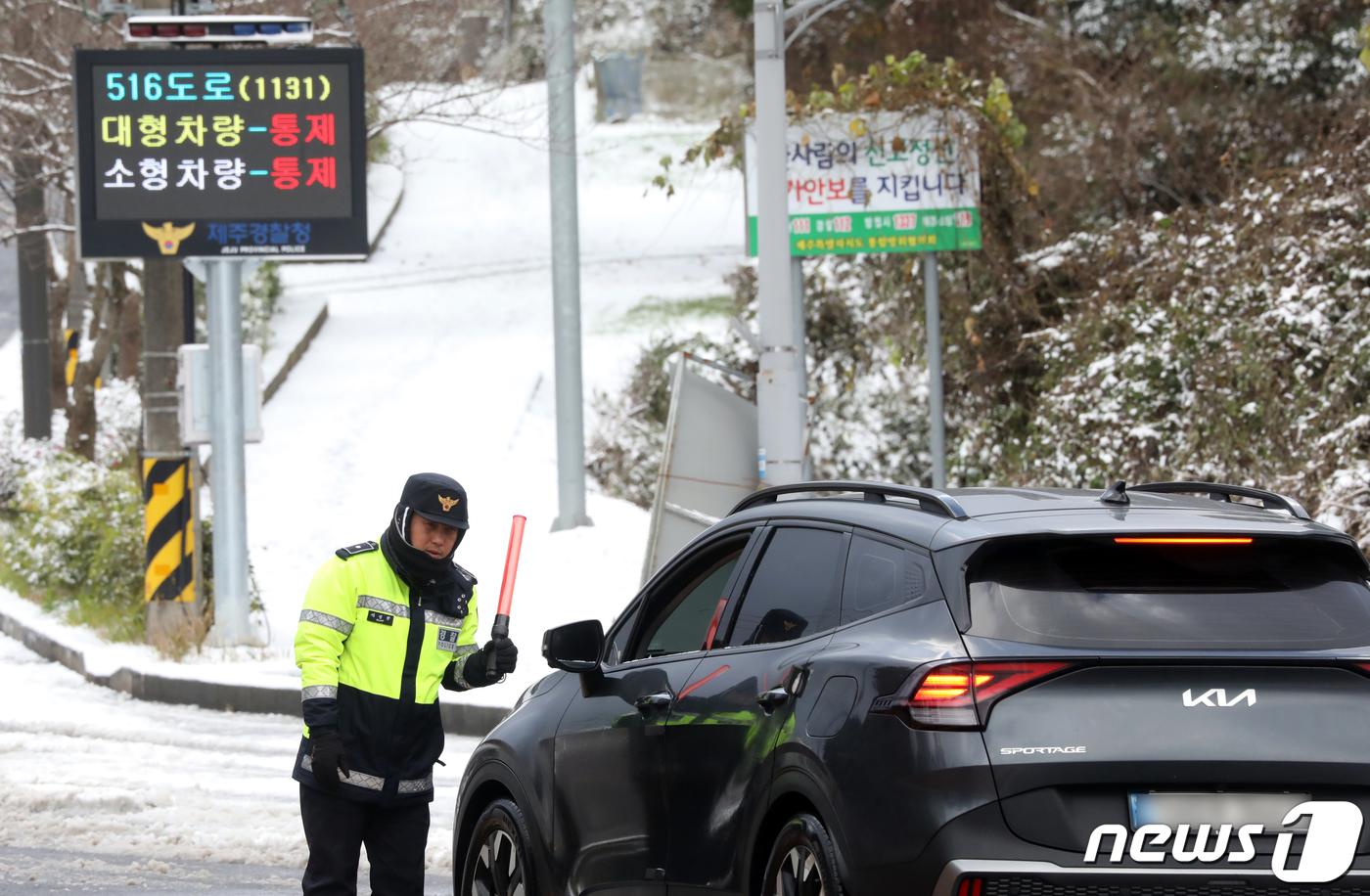 (제주=뉴스1) 오현지 기자 = 전국 곳곳에 폭설과 한파가 닥친 21일 오후 제주시 제주대학교 사거리에서 경찰이 516도로 진입을 통제하고 있다. 2023.12.21/뉴스1