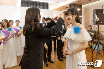 본문 이미지 -  코웨이 물빛소리 합창단 신규 단원이 사원증을 전달받고 있다..(코웨이 제공)