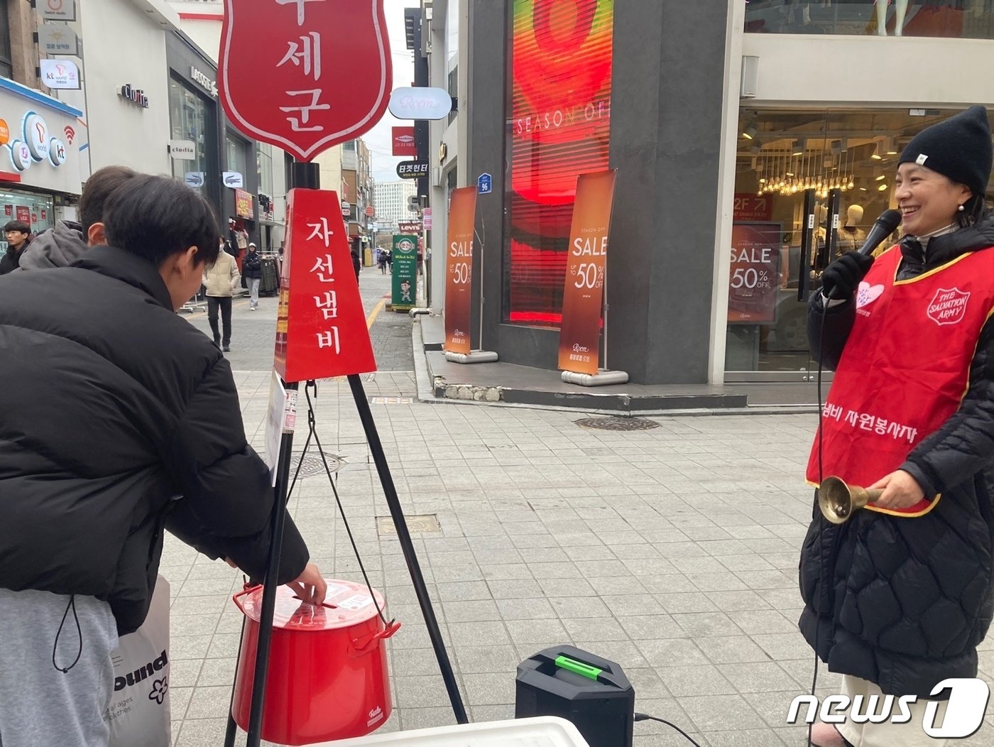 본문 이미지 - 한 시민이 광주 동구 충장로에 마련된 구세군의 자선냄비에 기부를 하고 있다. 2023.12.19/뉴스1 조현우 인턴기자