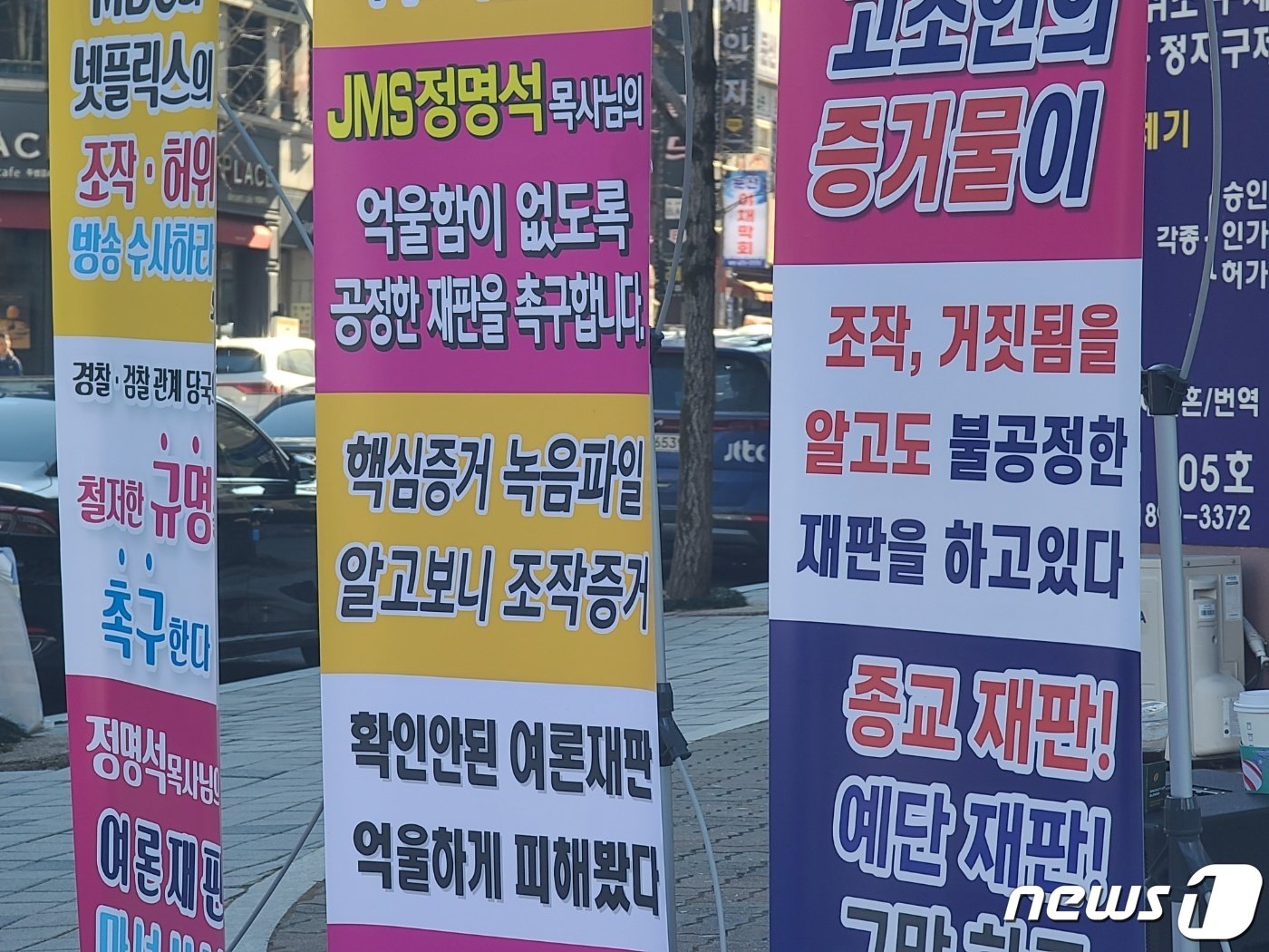 본문 이미지 - JMS 정명석 총재에 대한 1심 판결 선고일인 22일 대전지법 정문 맞은편에 정씨의 무죄를 주장하는 입간판이 늘어서 있다./뉴스1 