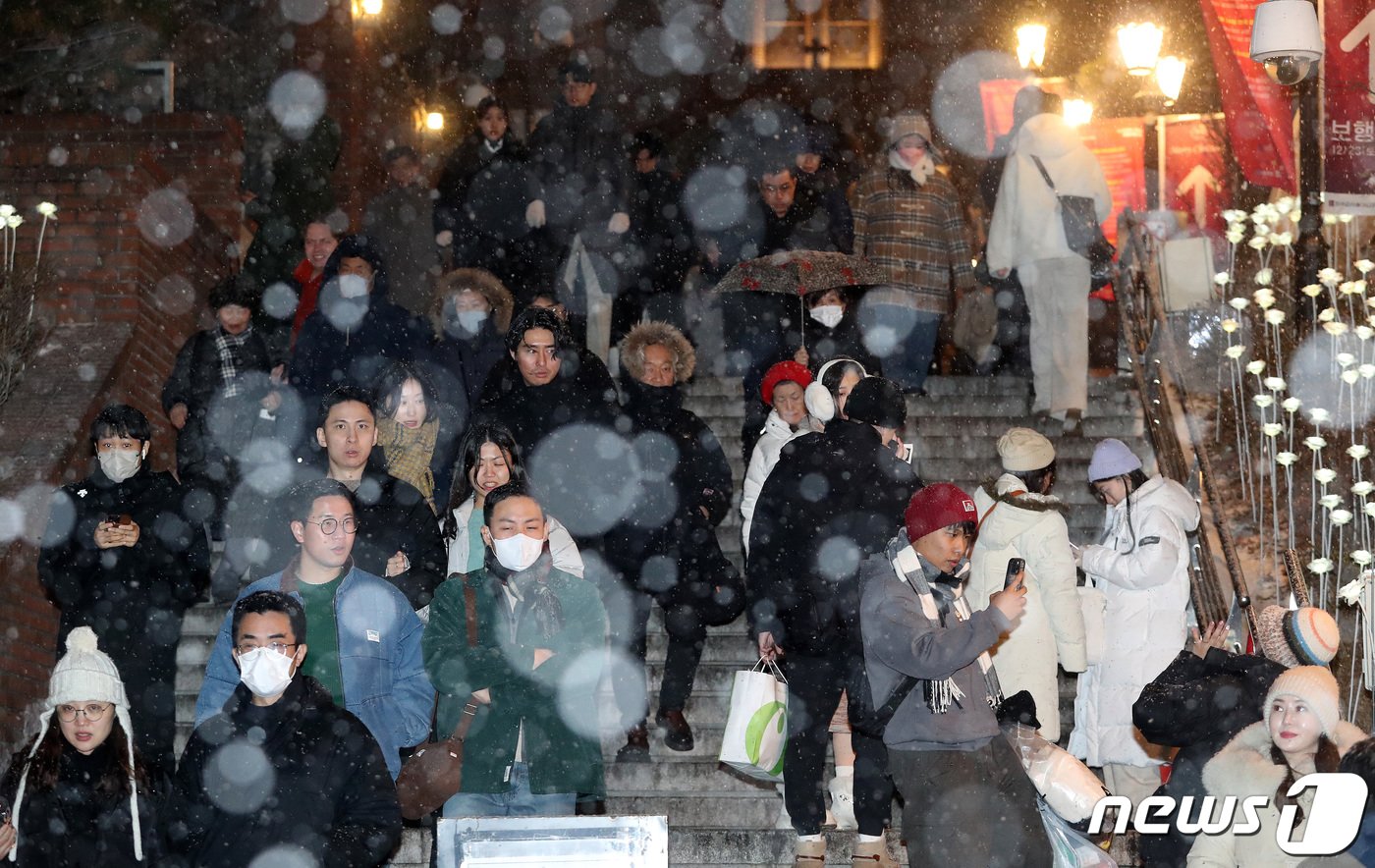 본문 이미지 - 서울을 비롯한 중부지역에 눈이 내리고 있는 25일 새벽 서울 중구 명동성당에서 자정미사를 마친 신자들이 눈을 맞으며 성당을 나서고 있다. 서울은 이번 눈으로 8년만에 화이트 크리스마스다. 2023.12.25/뉴스1 ⓒ News1 박세연 기자