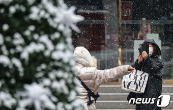 본문 이미지 - 8년 만에 화이트 크리스마스가 찾아온 25일 오전 서울 중구 명동거리를 찾은 관광객들이 즐거운 시간을 보내고 있다. 2023.12.25/뉴스1 ⓒ News1 김도우 기자