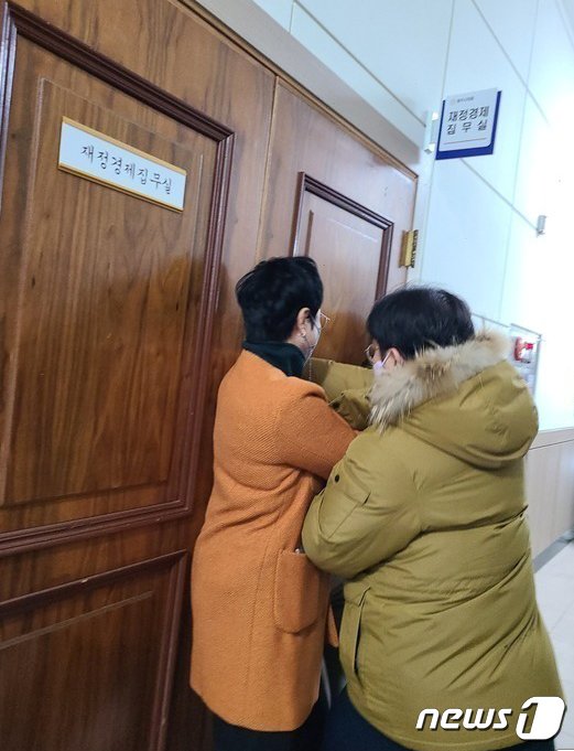 본문 이미지 - 청주시청 본관동 철거에 반대하는 청주시의회 더불어민주당 의원들이 지난해 12월20일 4차 본회의에 참석하려는 같은 당 임정수 의원을 재정경제위원회 집무실에 데리고 간 뒤 설득하고 있다. 임 의원이 집무실을 나오려 하자 민주당 의원들이 문을 막고 있다