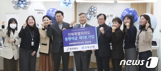 본문 이미지 - 전북은행이 전북특별자치도 성공 출범 기원과 도민 홍보를 목적으로 ‘전북특별자치도 동행적금’ 상품을 19일 출시한 가운데 전북은행 도청지점에서 김관영 전북지사가 현장가입 후 기념 촬영을 하고 있다.2023.12.19.(전북도 제공)/뉴스1