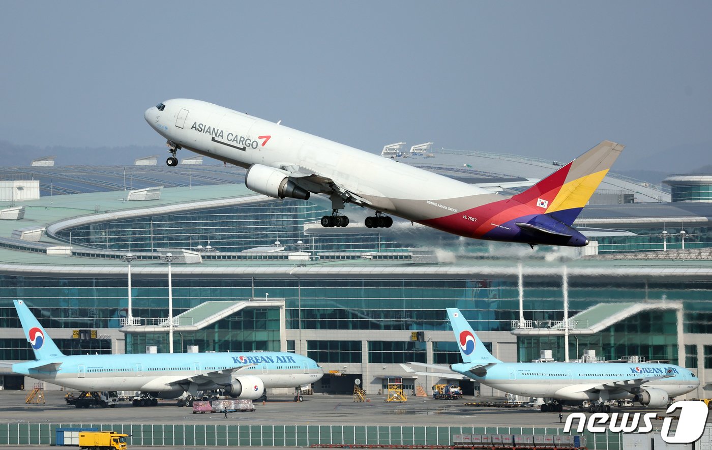 대한항공과 아시아나항공의 합병이 해를 넘기게 된 가운데 26일 오후 인천국제공항 계류장에 대한항공과 아시아나항공의 항공기가 지나고 있다.  2023.12.26/뉴스1 ⓒ News1 박정호 기자