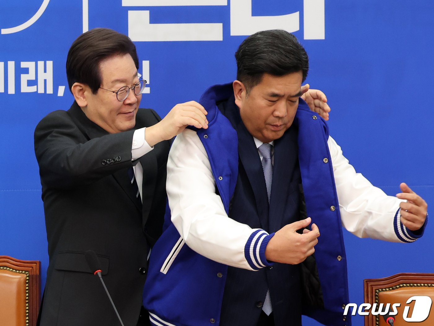 본문 이미지 - 이재명 더불어민주당 대표가 27일 오전 서울 여의도 국회에서 열린 민주당 4·5호 인재영입식에서 인재영입 5호 강청희 전 대한의사협회 상근부회장에게 당 점퍼를 입혀주고 있다.  2023.12.27/뉴스1 ⓒ News1 황기선 기자