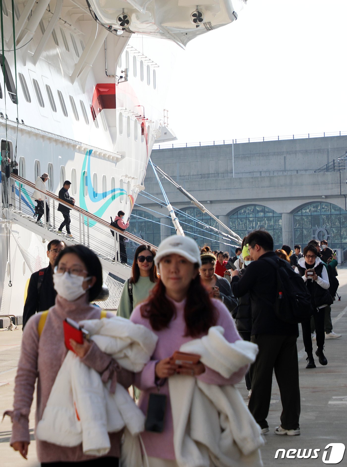 본문 이미지 - 중국 첫 13만톤급 대형 크루즈선인 &#39;아도라 매직 시티&#40;Adora Magic City&#41;호&#39; 탑승객들이 28일 오전 서귀포시 강정동 제주민군복합형관광미항에 내리고 있다. 이번에 처음으로 제주를 찾은 이 크루즈선은 내년 약 80회에 걸쳐 다시 제주를 찾는다.2023.12.28./뉴스1 ⓒ News1 오미란 기자