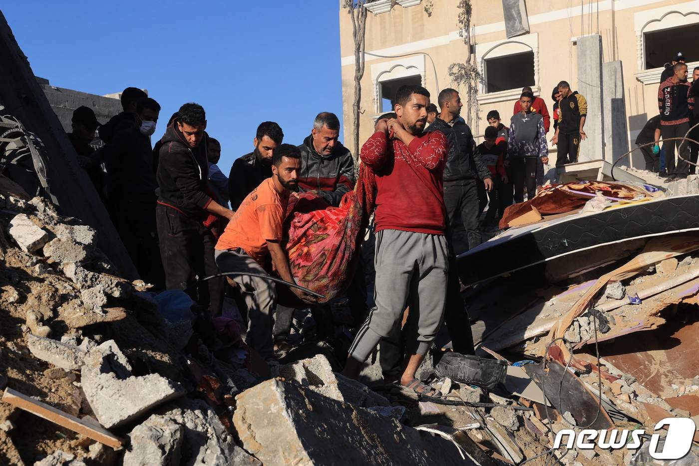(라파 AFP=뉴스1) 정지윤 기자 = 가자지구 라파 지역에서 3일(현지시간) 주민들이 이스라엘의 폭격으로 무너진 건물 사이에서 발견한 희생자의 시신을 천에 둘러 옮기고 있다. 2 …