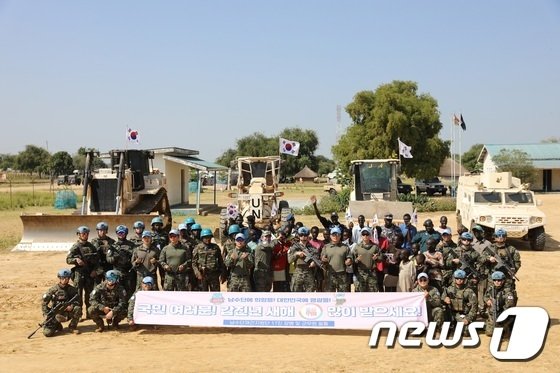 한빛부대원들이 남수단 보르시내 재건지원작전 중 현지인들과 함께 새해 인사를 하고 있다. &#40;합동참모본부 제공&#41; 2023.12.31/뉴스1