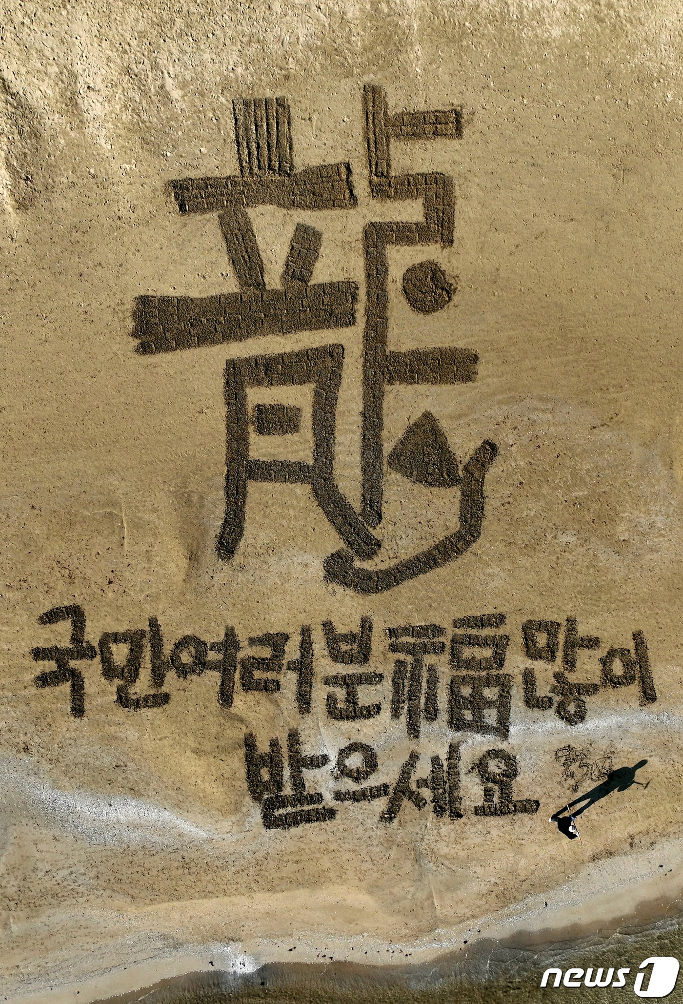 본문 이미지 - 서예가 김동욱 씨가 31일 경북 포항시 북구 영일대해수욕장 백사장에서 갑진년 용(龍)의 해를 앞두고 대형 용 글자를 쓰며 국태민안, 태평성태를 기원하고 있다.2023.12.31/뉴스1 ⓒ News1 최창호 기자