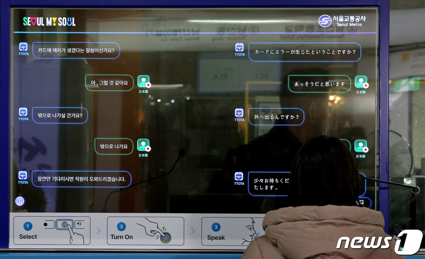 (서울=뉴스1) 장수영 기자 = 4일 오후 서울 중구 명동역을 찾은 외국인 관광객이 인공지능(AI) 기반 외국어 동시 대화 시스템을 통해 카드 오류 해결 방법을 안내받고 있다.서울 …