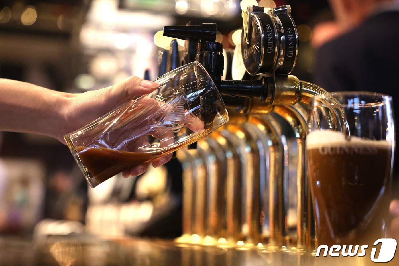 본문 이미지 - 지난달 22일(현지시간) 영국 런던의 한 술집에서 종업원이 생맥주를 따르는 모습이다. 2023.11.22. ⓒ AFP=뉴스1