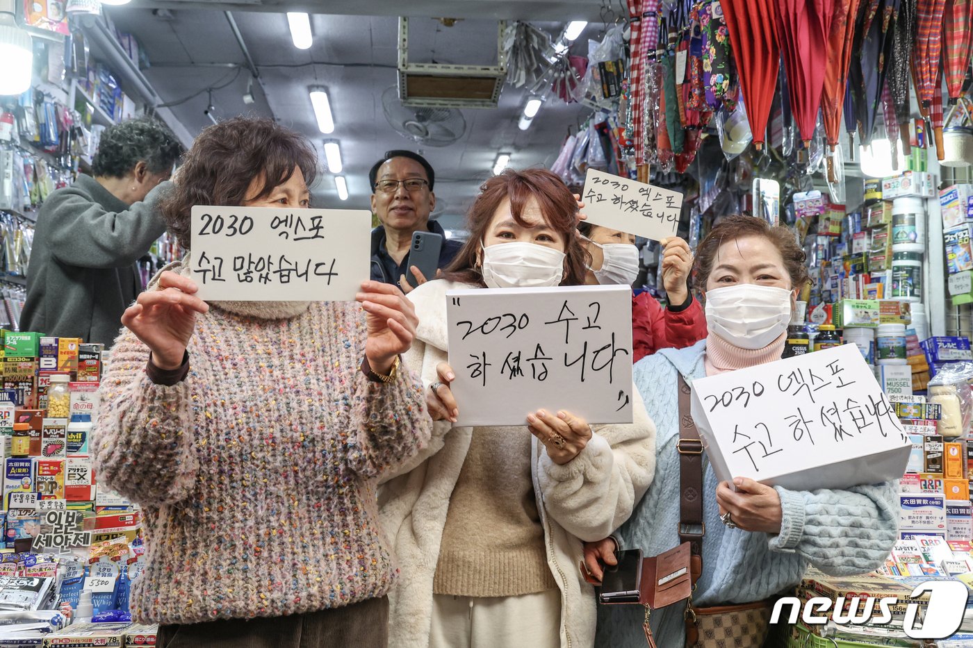 본문 이미지 - 6일 부산 중구 깡통시장에서 윤석열 대통령의 방문을 앞두고 부산 시민들이 윤 대통령의 부산엑스포 유치활동에 대한 감사 메시지를 보여주며 환영하고 있다. 2023.12.6/뉴스1 ⓒ News1 부산사진공동취재단