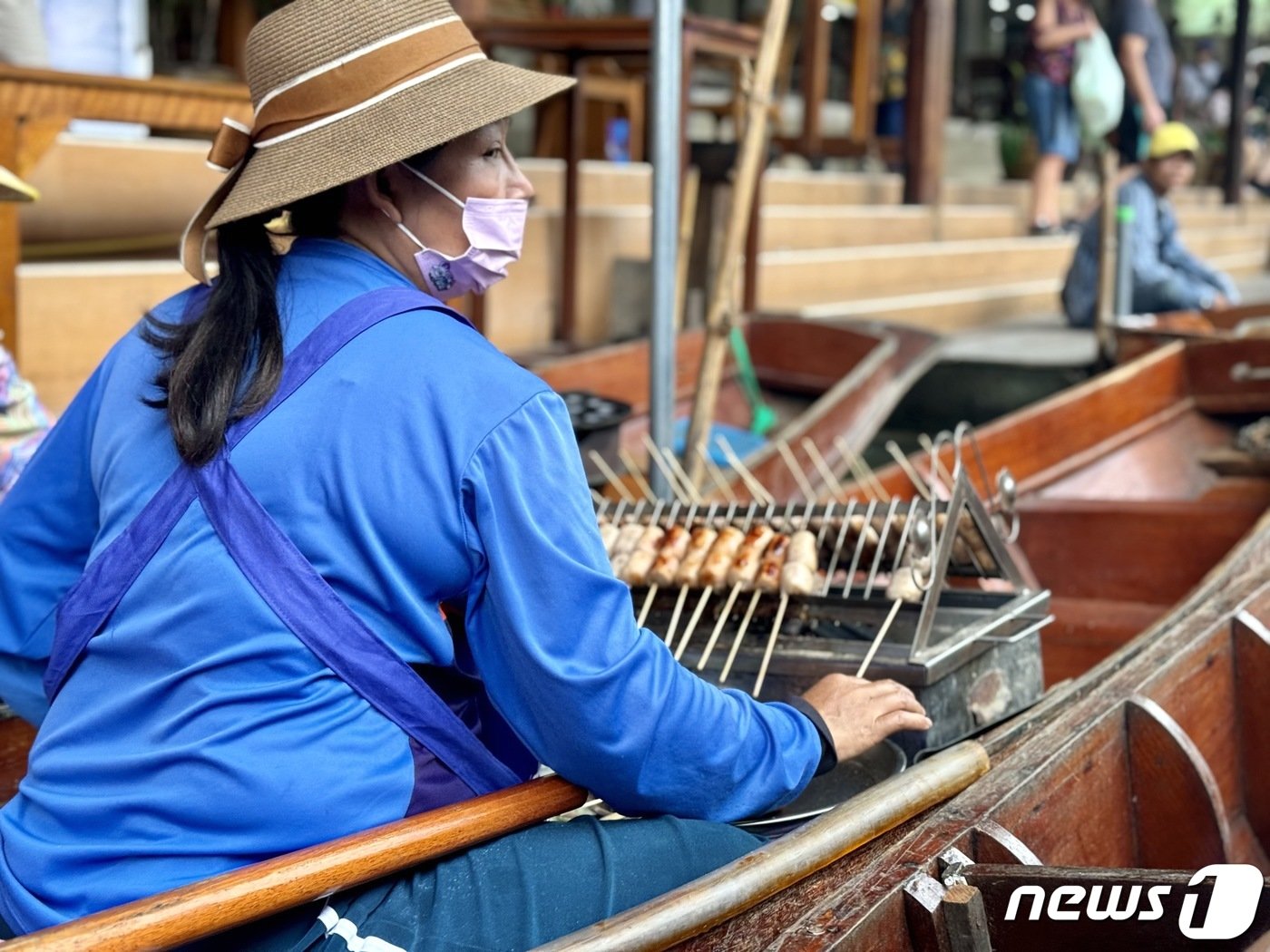 담넌사두억 수상 시장에서 한 상인이 꼬치구이를 팔고 있다. ⓒ News1 이민주 기자