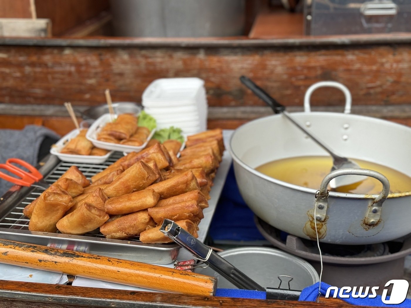 본문 이미지 - 담넌사두억 수상 시장에서 한 상인이 춘권을 팔고 있다. ⓒ News1 이민주 기자