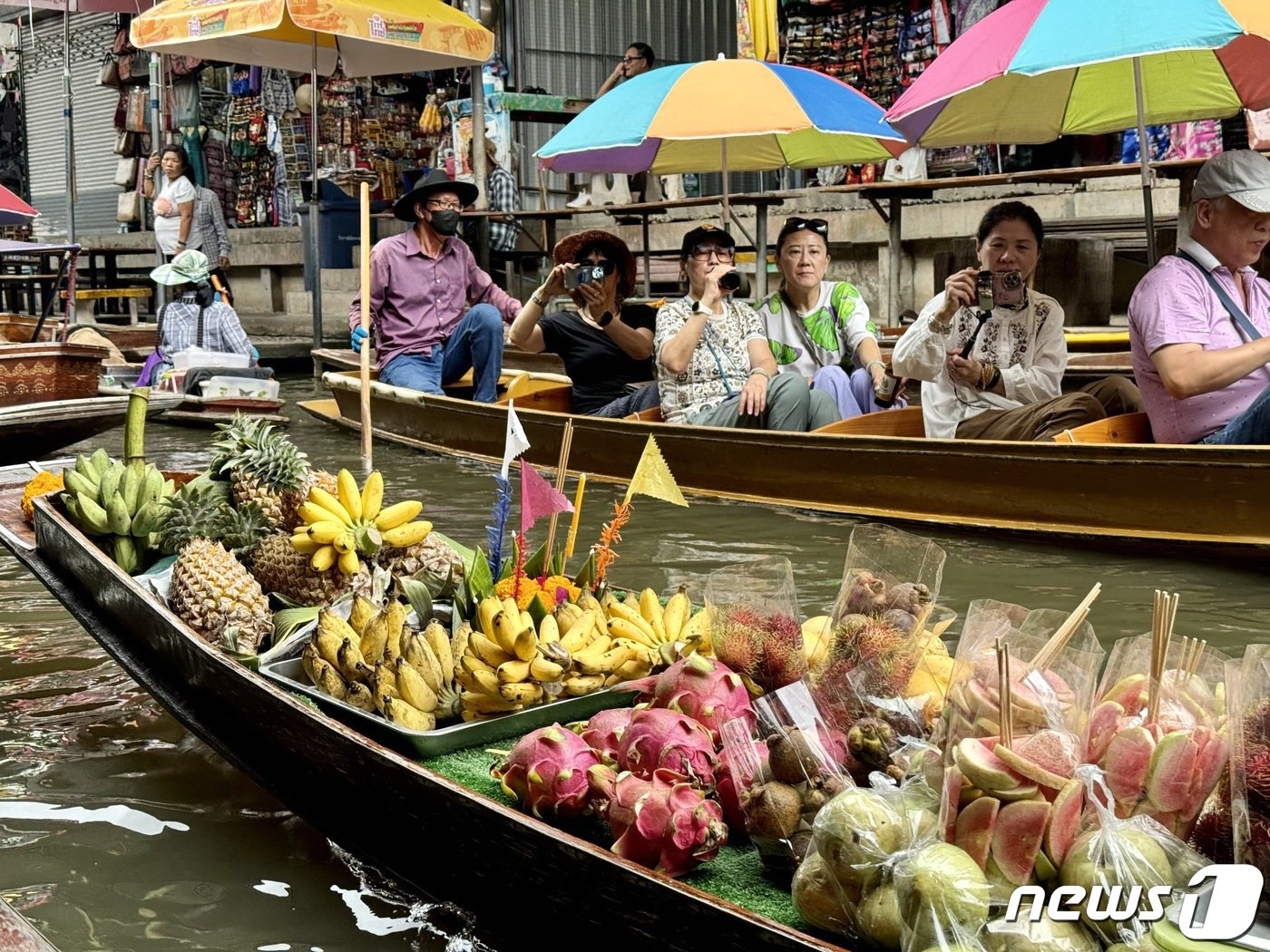 본문 이미지 - 담넌사두억 수상 시장 한 가운데 과일을 파는 상인이 있다. ⓒ News1 이민주 기자