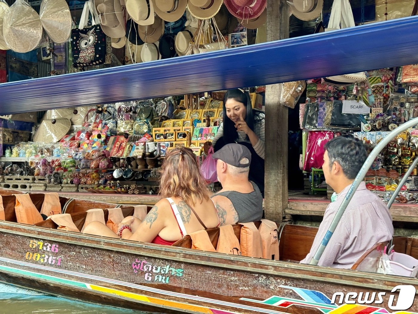 본문 이미지 - 담넌사두억 수상 시장의 한 상인이 관광객들을 상대로 호객 행위를 한다. ⓒ News1 이민주 기자