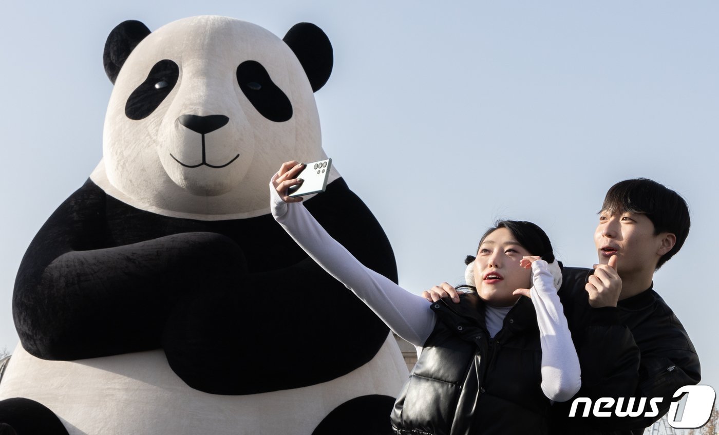 본문 이미지 - 7일 오전 경기도 용인시 처인구 에버랜드에서 모델들이 푸바오를 모티브로 만든 초대형 판다 '자이언트 바오'를 배경으로 기념 촬영을 하고 있다. 자이언트 바오는 아파트 4층(약 12미터) 높이의 크기로 만들어 졌다. 2023.12.7/뉴스1 ⓒ News1 이재명 기자