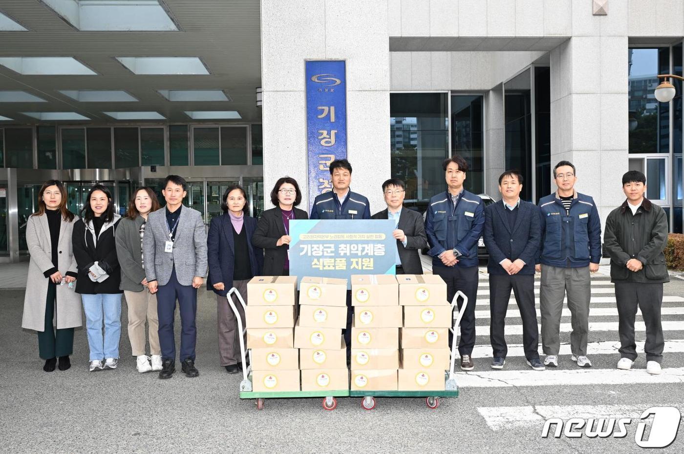 김진용 고리원자력본부 노조위원장&#40;사진 가운데&#41;과 임현철 경영지원실장&#40;사진 오른쪽 다섯 번째&#41;이 식료품 전달 후 기장군 관계자들과 함께 기념촬영을 하고 있다&#40;고리원전 제공&#41;