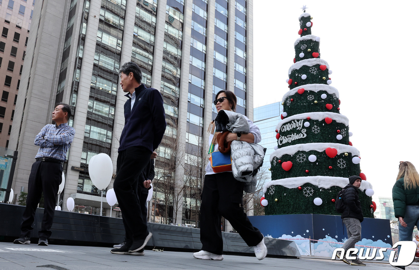 (서울=뉴스1) 이동해 기자 = 서울의 낮 최고기온이 16도까지 오르며 포근한 날씨를 보인 8일 서울 중구 청계천 광장에 마련된 크리스마스 트리 앞으로 가벼운 옷차림의 시민들이 산 …