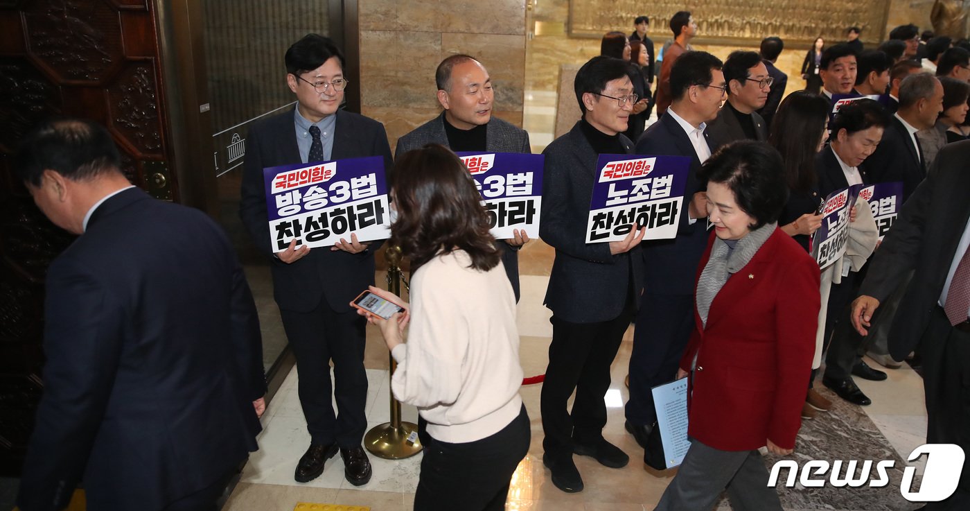 본문 이미지 - 국민의힘 의원들이 8일 오후 서울 여의도 국회 로텐더홀에서 노조법 및 방송3법 찬성 촉구 피켓팅을 펼치는 더불어민주당 의원들 앞을 지나 본회의장으로 들어서고 있다. 2023.12.8/뉴스1 ⓒ News1 임세영 기자