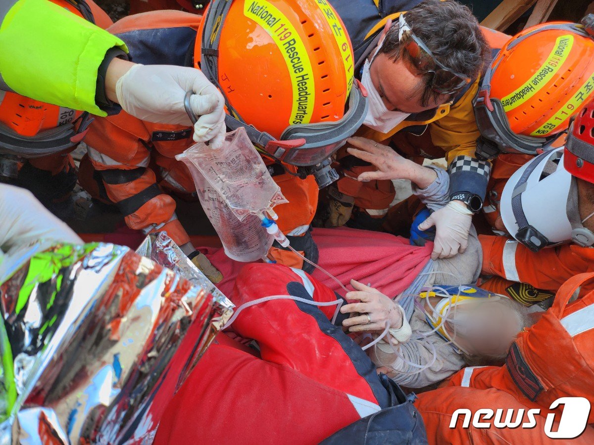 본문 이미지 - 지난11일(현지시간) 튀르키예 지진 피해 지역에서 대한민국 긴급구호대 대원들이 65세 여성 생존자를 구조하고 있다. (대한민국 긴급구호대(KDRT)제공) 2023.2.12/뉴스1