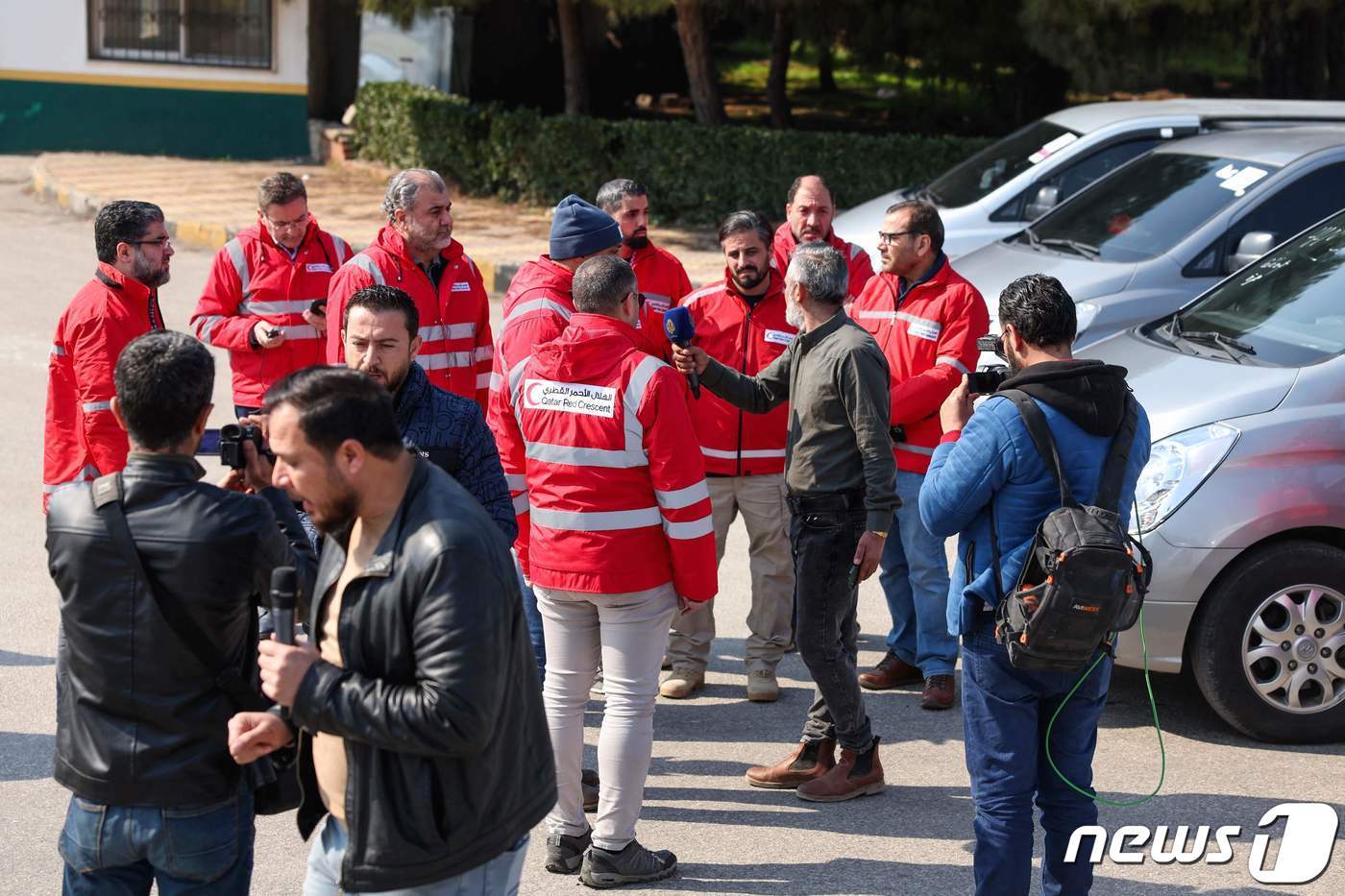본문 이미지 - 12일(현지시간) 시리아 북서부 이들리브주에서 카타르 의료진이 대지진 피해를 입은 시리아 반군 점령지역으로 넘어가기 위해 국경 인근에 모였다. 빨간 점퍼를 입은 대원들이 인터뷰를 하고 있다. ⓒ AFP=뉴스1 ⓒ News1 권진영 기자