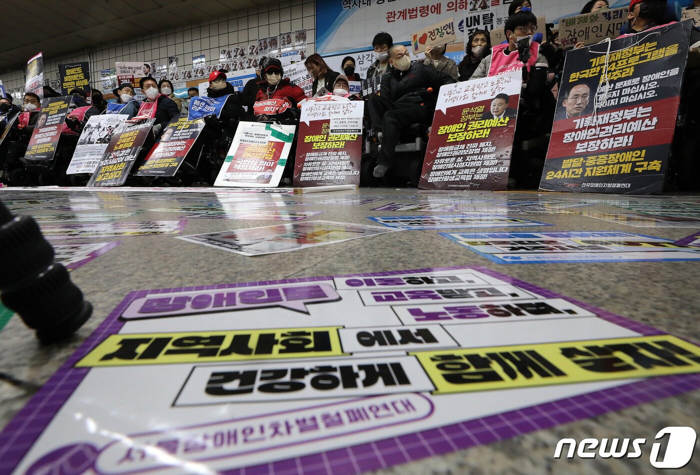 본문 이미지 - 13일 오전 서울 용산구 삼긱지역 승강장에서 '시민과 함께하는 달보기 운동 함께 선언 기자회견'이 열린 가운데 역사 바닥에 전장연이 요구하는 선전물 스티커가 붙어져 있다. 2023.2.13/뉴스1 ⓒ News1 이동해 기자
