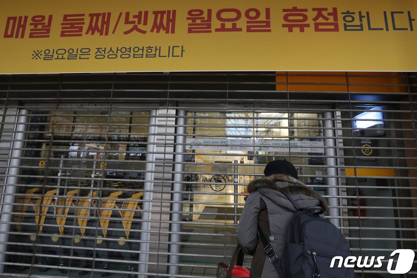 본문 이미지 - 대구 지역의 대형마트 의무휴업일이 일요일에서 평일인 월요일로 변경된 13일 오후 휴점에 들어간 대구 수성구 한 대형마트 출입문이 닫혀 있다. 휴업일 변경을 모른 채 장을 보기 위해 마트를 찾은 한 시민이 문 닫은 마트 내부를 바라보고 있다. 2023.2.13/뉴스1 ⓒ News1 공정식 기자