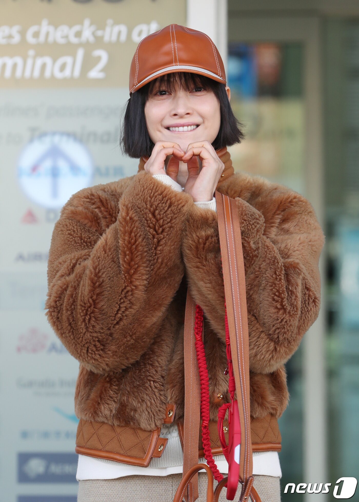 본문 이미지 - 배우 이나영이 패션 행사 참석차 15일 인천국제공항에 도착해 이탈리아 밀라노로 출국하기 전 하트로 인사를 전하고 있다. ⓒ News1 권현진 기자