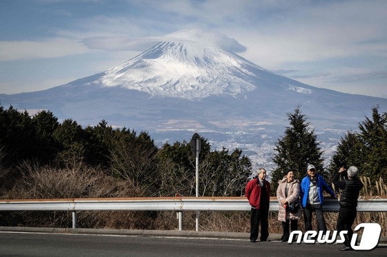 일본 시즈오카현(県) 한 도로에서 관광객들이 후지산을 배경으로 사진을 찍고 있다. © AFP=뉴스1 © News1 권진영 기자