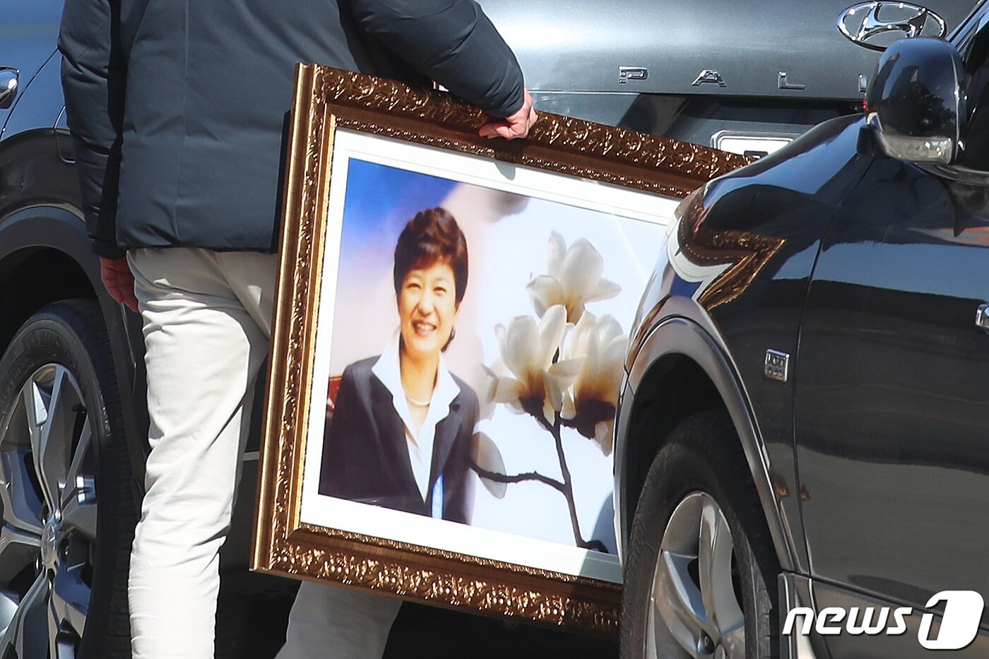 본문 이미지 - 2일 오전 대구 달성군 유가읍 박근혜 전 대통령 사저 앞에서 열린 생일 축하 행사에서 황교안 전 미래통합당 대표와 지지자들이 선물한 박 전 대통령 존영(사진)과 목련이 담긴 액자를 경호처 관계자가 전달받아 들고 사저로 들어가고 있다. 2023.2.2/뉴스1 ⓒ News1 공정식 기자